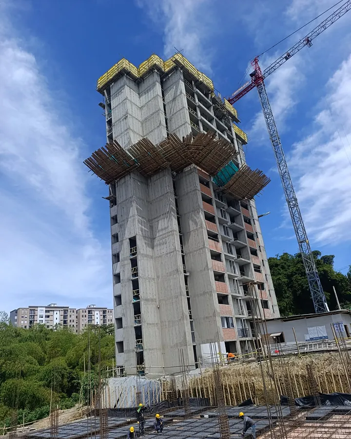 Torre de 16 pisos en estructura con su torre grúa y la protección perimetral en los últimos niveles